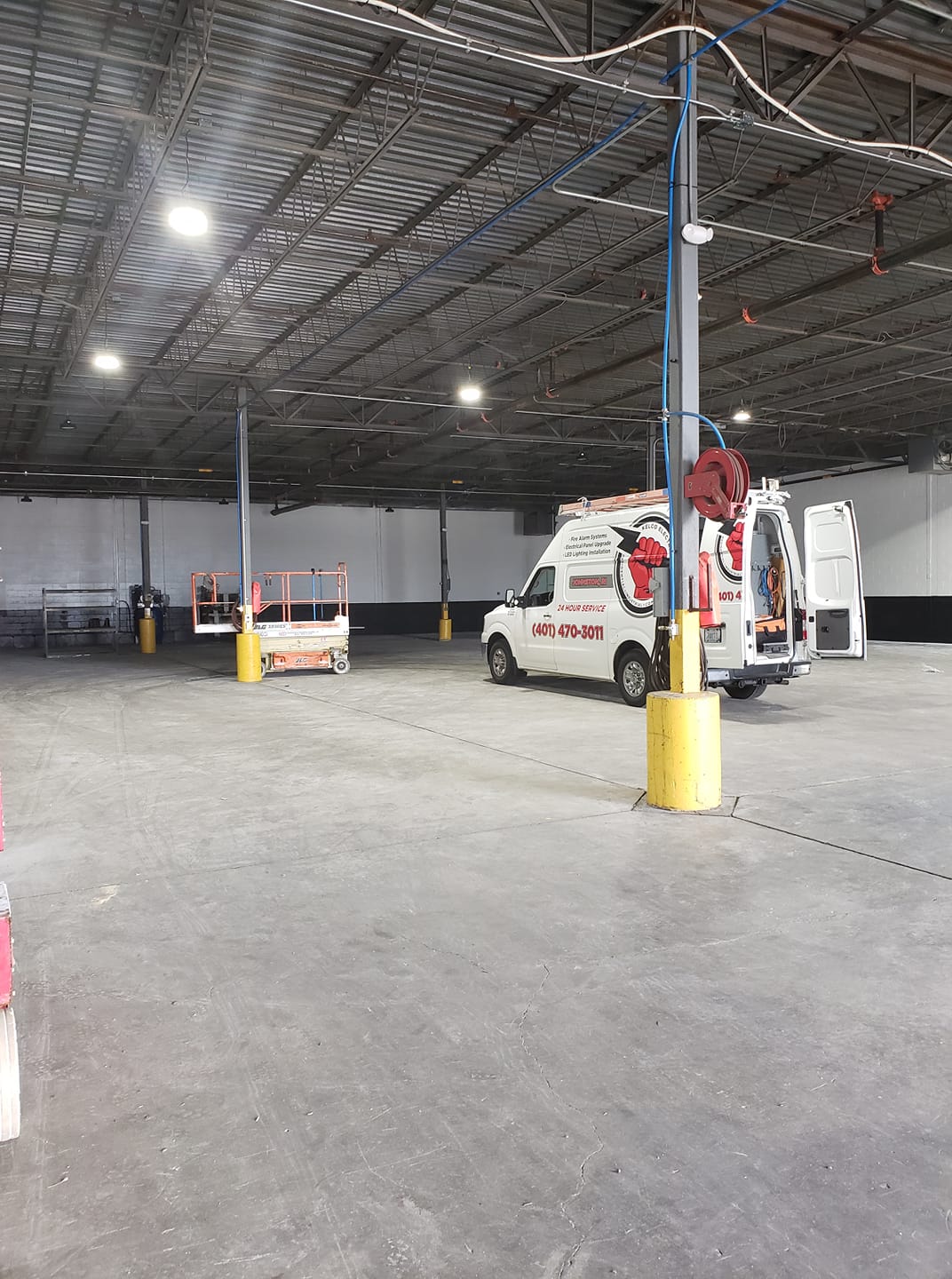 Kelco Electric van and lift parked inside a warehouse job in Rhode Island